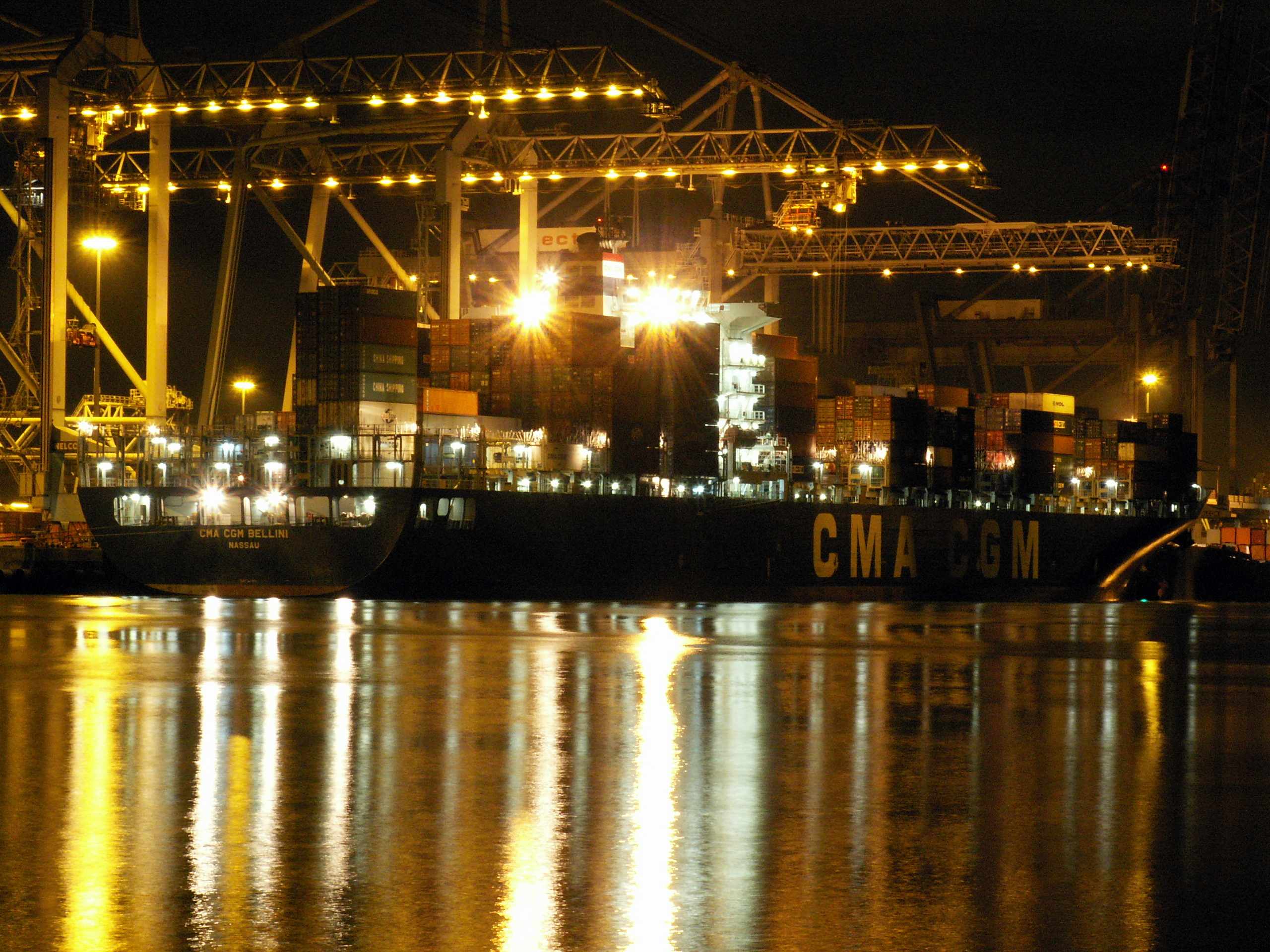 Floodlit container ship and gantry cranes at night